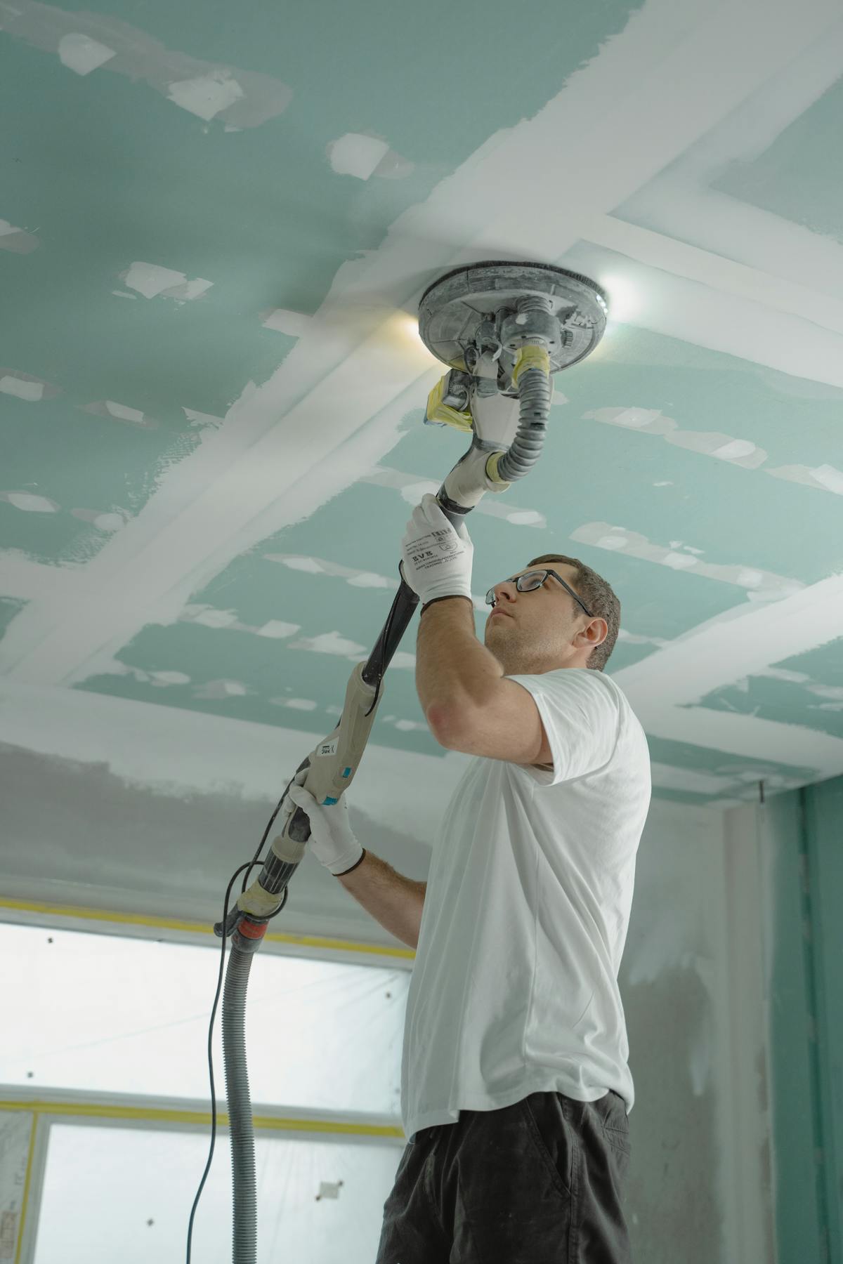 Patches In A Day specialist sanding a freshly patched drywall ceiling in a Sonoma County home