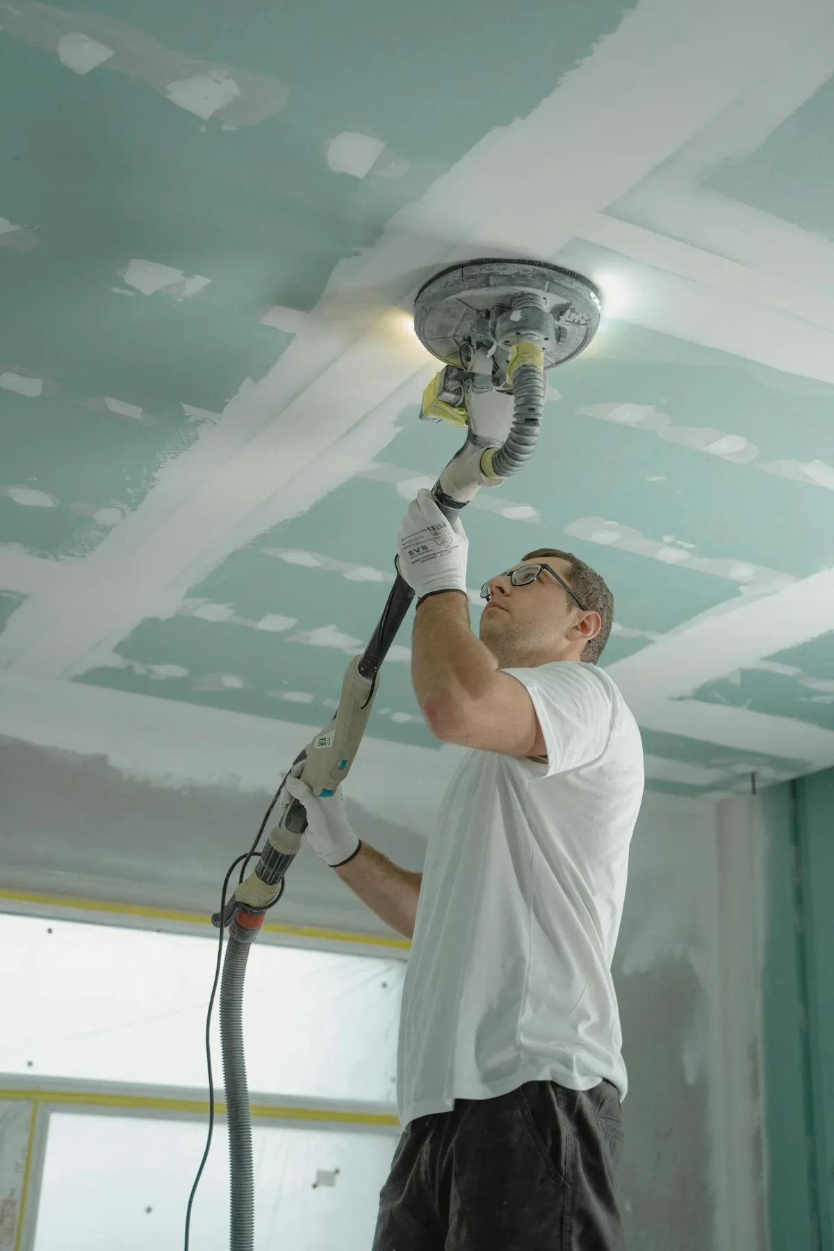 Patches In A Day specialist sanding a freshly patched drywall ceiling in a Sonoma County home