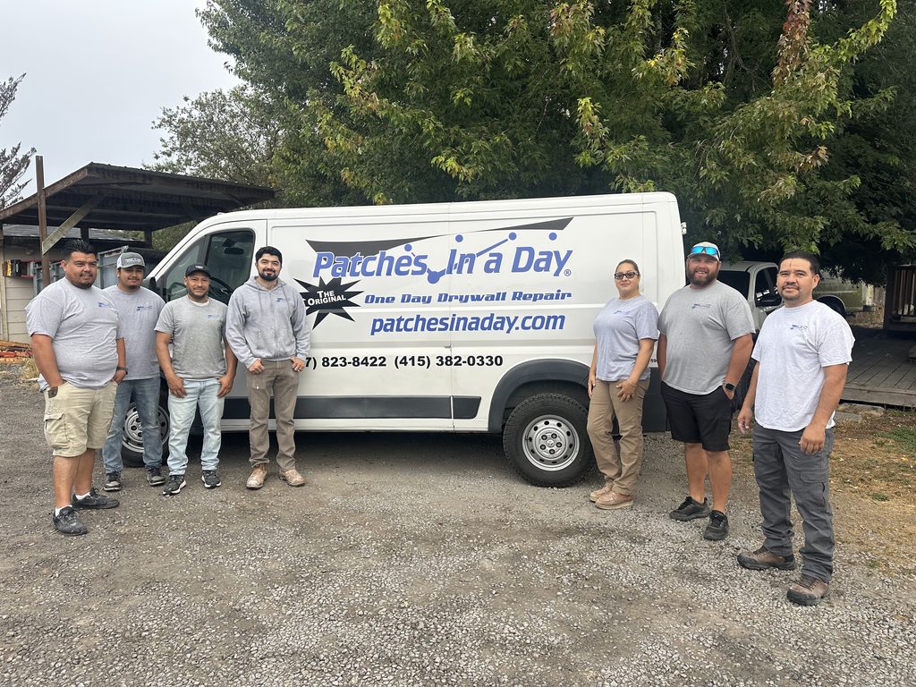 The Patches In A Day crew standing with a company van marked Patches In A Day — One Day Drywall Repair